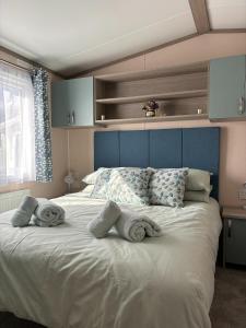 ein Schlafzimmer mit einem großen Bett mit Handtüchern darauf in der Unterkunft Regal Beachside pitch 22 Creek Caravan Park in Ringstead