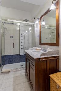 uma casa de banho com um chuveiro, um lavatório e um espelho. em Albergo La Marina B&B em Deiva Marina