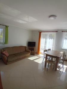 a living room with a couch and a table at Domimat-Lila in Dębki