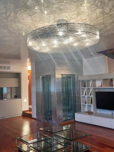 a living room with a chandelier and some glass tables at Villa Vanessa SUITES in Lugano