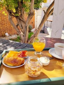 una mesa con una bandeja de comida y un vaso de zumo de naranja en Hotel Namaste en Mendoza