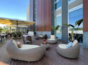 a patio with chairs and tables on a building at H2C Hotel Milanofiori in Assago