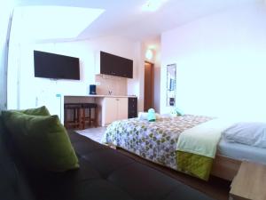 a hotel room with a bed and a couch at Guesthouse Cecilia 2 in Malinska