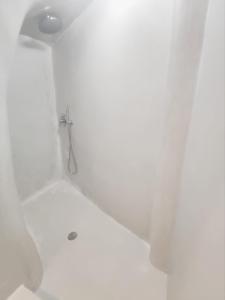 a shower in a white bathroom with a shower at Low Cost Fira Center Rooms in Fira