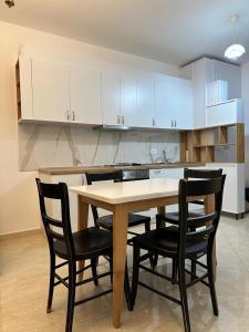 cocina con mesa de madera y sillas negras en Apartament 1+1 en Yrsheku