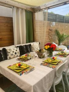 een tafel met een witte tafeldoek en bloemen erop bij Jasmin House 2 in Cenon