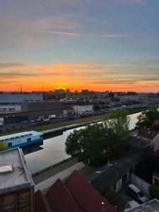a sunset over a city with a river at Appartement d’artiste in Saint-Denis