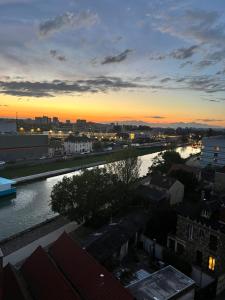 a view of a river in a city at sunset at Appartement d’artiste in Saint-Denis