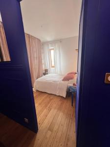 a bedroom with a bed and a wooden floor at Appartement d’artiste in Saint-Denis