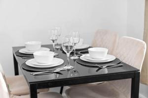 a black table with plates and wine glasses on it at Perfect house for large groups and families in Leicester