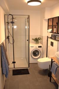 een badkamer met een douche en een wasmachine bij Eröffnungsangebot Übernachten im Herzen Bremens in Bremen