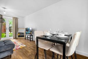 a dining room with a black table and white chairs at Perfect house for large groups and families in Leicester