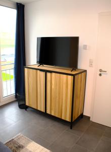 een flatscreen-tv op een stand in een kamer bij Eröffnungsangebot Übernachten im Herzen Bremens in Bremen