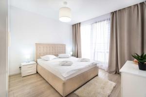 ein weißes Schlafzimmer mit einem großen Bett und einem Fenster in der Unterkunft Jasmine Luxury Aviatiei in Herăstrău