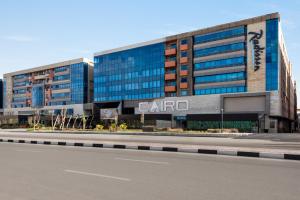 a large building with a carota sign on the side of a road at Radisson Residences Cairo Heliopolis in Cairo