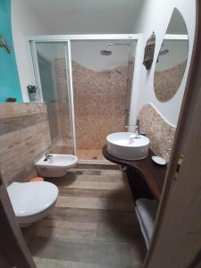 een badkamer met een toilet, een wastafel en een spiegel bij Casa Sherazad in Tías