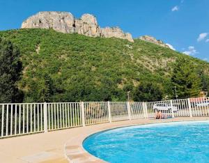 uma piscina com uma cerca e uma montanha em Le Dignois em Digne-Les-Bains