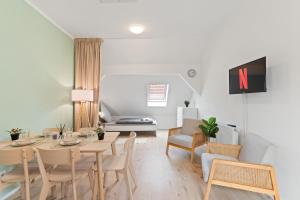 a dining room and living room with a table and chairs at Apartmenthaus Nürtingen Zentrum Kitchen,Wifi,Smart TV *** in Nürtingen