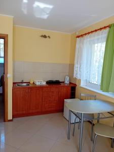 a kitchen with a table and a table and a window at Domimat-Lila in Dębki