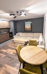 - un salon avec un canapé et une table dans l'établissement Apartament Górski z widokiem na góry w Bieszczadach - 3 sypialnie 80m2, à Ustrzyki Dolne