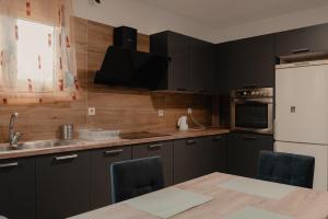 a kitchen with black cabinets and a white refrigerator at Saint Nektarios Ηouse Preveza in Preveza