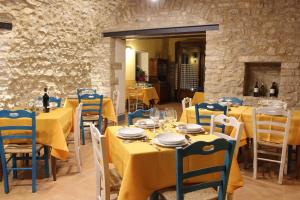 a dining room with yellow tables and blue chairs at Agriturismo Casale La Palombara in Cerreto di Spoleto