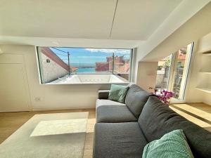 a living room with a couch and a large window at Doria House in Imperia