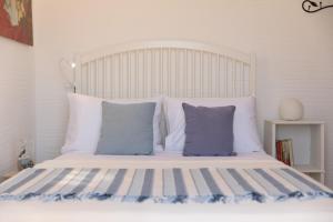 een bed met blauwe en witte kussens erop bij Apiliotis sunrise beach villa in Ligaridia