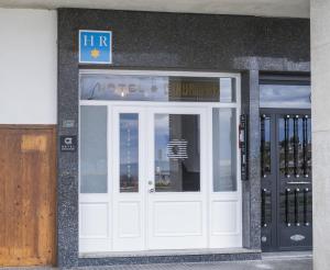 una puerta blanca de un edificio con una señal encima en Alda Coruñamar, en A Coruña