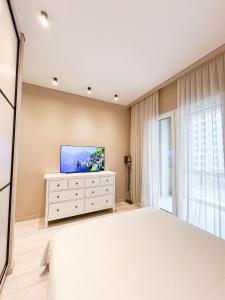 1 dormitorio con 1 cama y TV de pantalla plana en Фешенебельные апартаменты в ЖК 4YOU, en Baganashyl