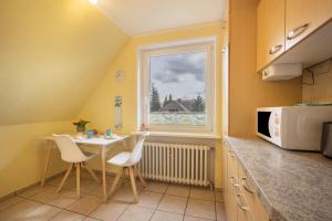 a kitchen with a table and chairs and a window at Ferienwohnung Krempermoor 2 in Krempermoor