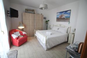 モノーポリにあるB&B U Mare Mioのベッドルーム1室(ベッド1台、赤い椅子付)
