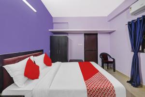 1 dormitorio con 1 cama con almohadas rojas y blancas en OYO Flagship 24 Stays, en Chinhat