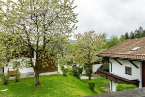 Blick auf einen Garten mit Bäumen und ein Haus in der Unterkunft Komfortwohnung mit Pool und Sauna in Hauzenberg