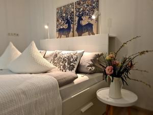 a bedroom with a couch and a vase with flowers on a table at FeWo Suhl-Heinrichs, 2 Schlafzimmer, 2 Terrassen in Suhl