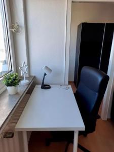 a white desk with a blue chair and a lamp at City-Wohnung mit Ausblick in Bochum