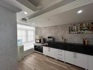 a kitchen with white cabinets and a black counter top at Hotel Yakut in Van