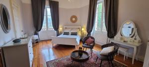 um quarto com uma cama, uma mesa e cadeiras em Le Manoir du Moulin de Madame em Villeneuve-sur-Lot