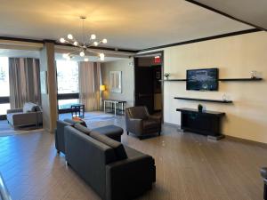 a living room with a couch and a tv at Wyndham Garden Schaumburg Chicago Northwest in Schaumburg