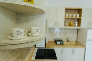two coffee cups sitting on a shelf in a kitchen at Vojvodjanska zora - besplatan parking in Sombor