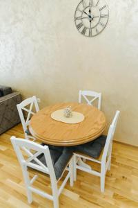 a wooden table and chairs with a clock on the wall at Vojvodjanska zora - besplatan parking in Sombor +22 photos