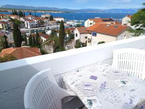 a table and chairs on a balcony with a view at Guesthouse Cecilia 2 in Malinska
