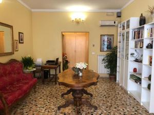 sala de estar con sofá rojo y mesa en B&B Myosotis, en Pisa