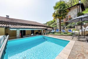 a swimming pool in front of a house at Residence Tatiana A3 in Tremosine Sul Garda