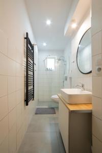 Baño blanco con lavabo y espejo en Apartment Rajzefiber - Spodek - MCK - NOSPR, en Katowice