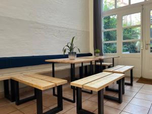eine Reihe von Tischen und Bänken in einem Restaurant in der Unterkunft Blue Doors Hostel Altstadt in Rostock