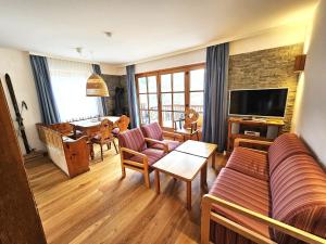 ein Wohnzimmer mit Couch und Fernseher in der Unterkunft Deluxe Panorama Apartment-Maibrunn-Alm in Bad Kleinkirchheim