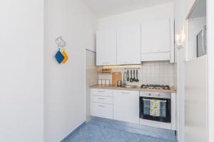Una cocina con gabinetes blancos y un horno de estufa. en Villa Marea, en Praiano 30 fotos más