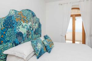 Un dormitorio con una cama con cabecero colorido y almohadas. en Villa Marea, en Praiano