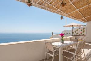 un tavolo e sedie su un balcone con vista sull'oceano di Villa Marea a Praiano